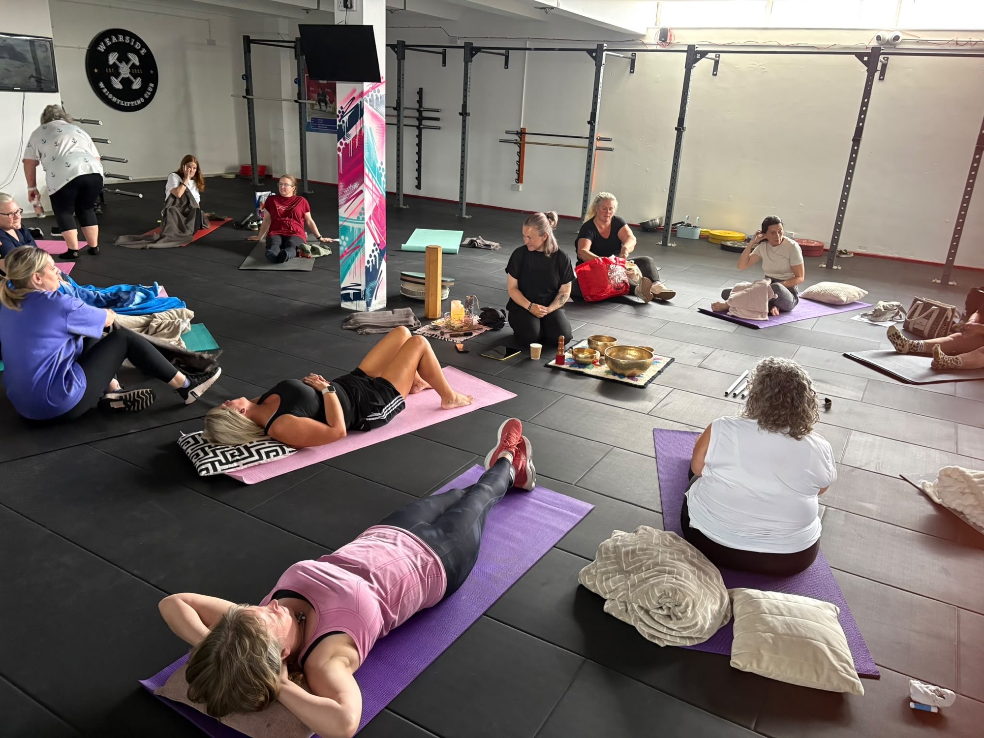 Members lying on mats with cushions and blankets during a relaxation session