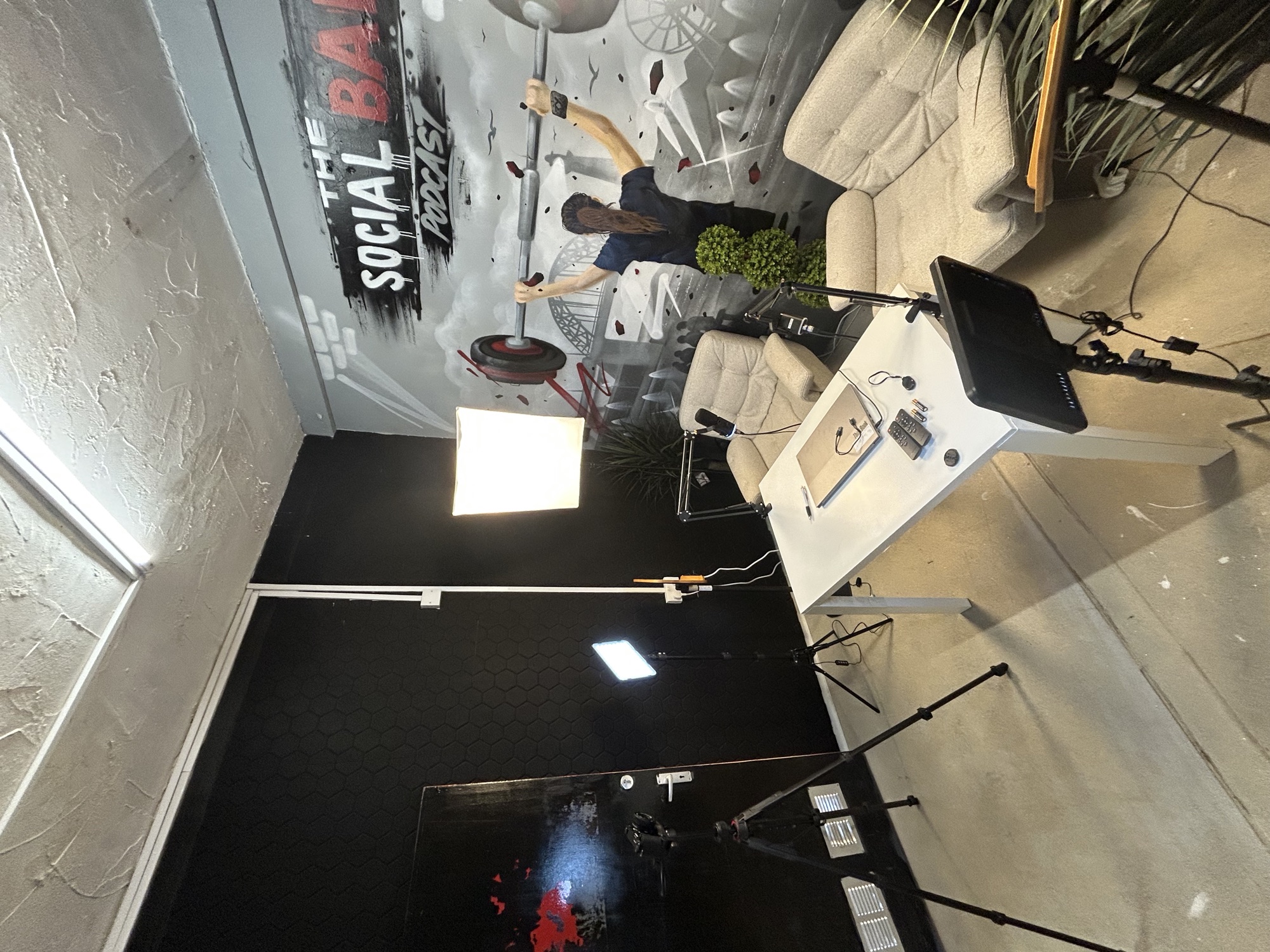 The podcast set: two chairs, lights and cameras in front of a painted Social Bar backdrop